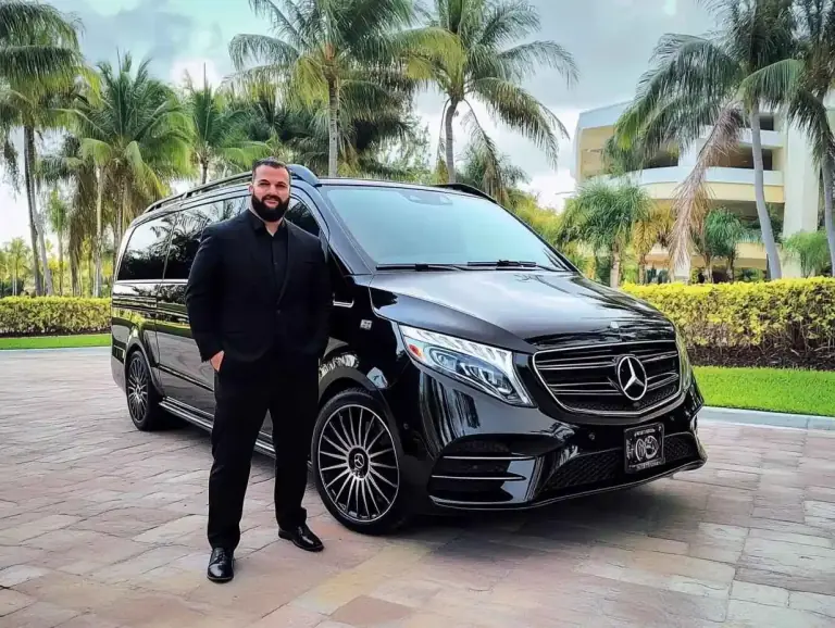 سائق تريبيانا يقف أمام مرسيدس V-Class سوداء جاهزة لرحلة يوم من لندن إلى قلاع كنت