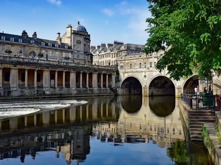 The colonnaded terrace beside Pulteney Bridge reflected in the River Avon