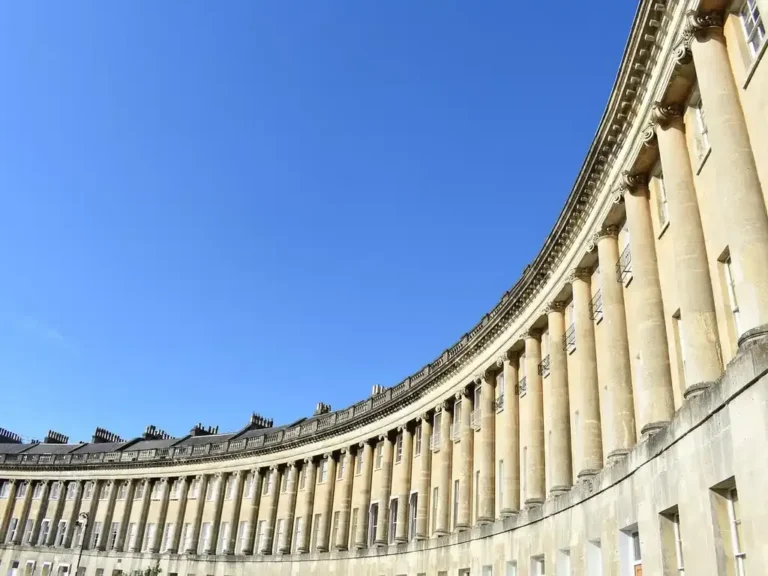 The curved Georgian colonnade of the Royal Crescent in Bath against a clear sky