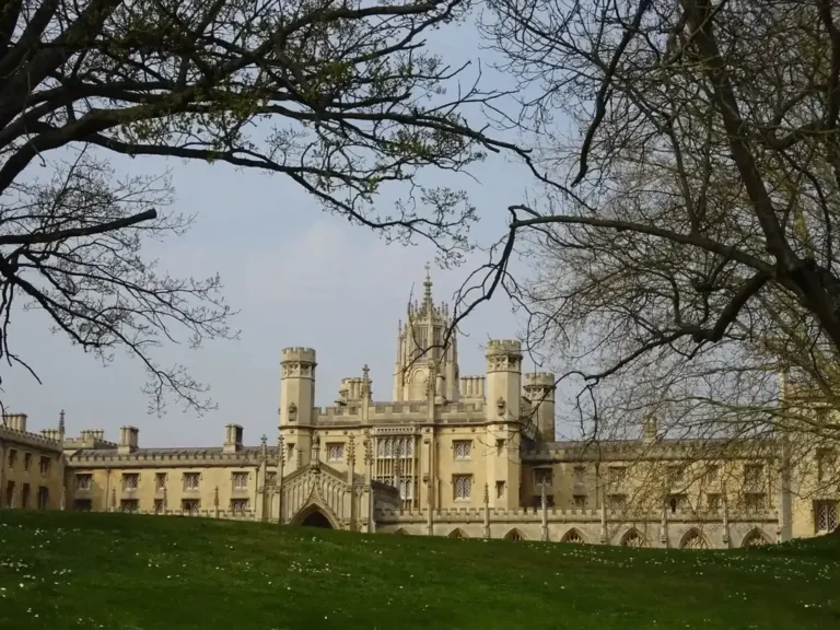 The turreted New Court of St John's College in Cambridge behind spring trees