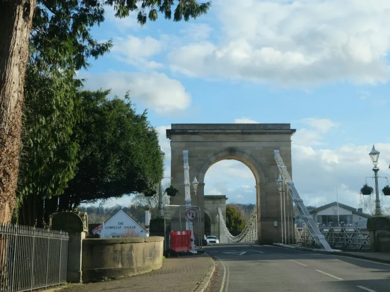 The stone arch of Marlow Suspension Bridge over the Thames, with the Compleat Angler beside it