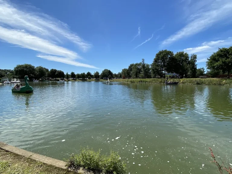 The boating lake and open parkland at Woburn Safari Park under a bright sky