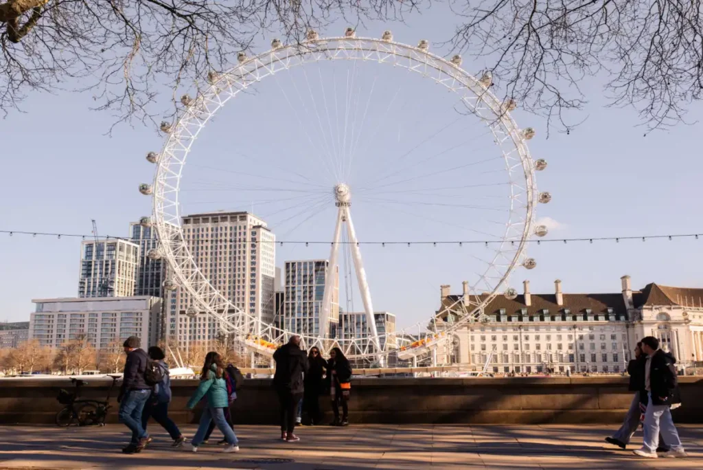 Visitors walking near the London Eye on a clear spring day