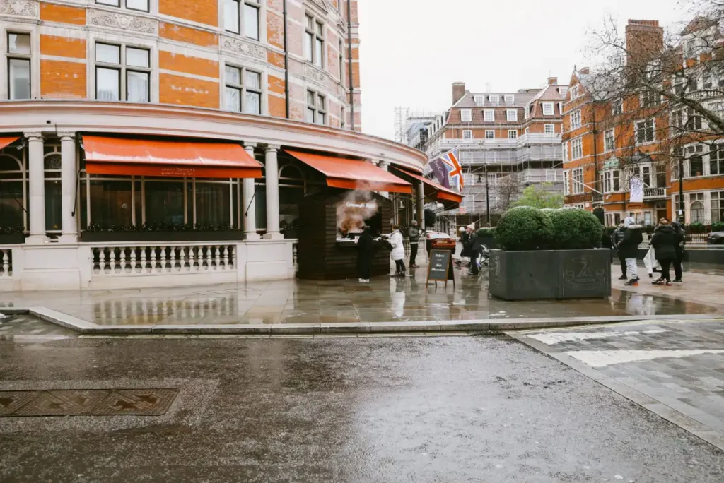 A wet London street with pedestrians and period architecture after a September shower