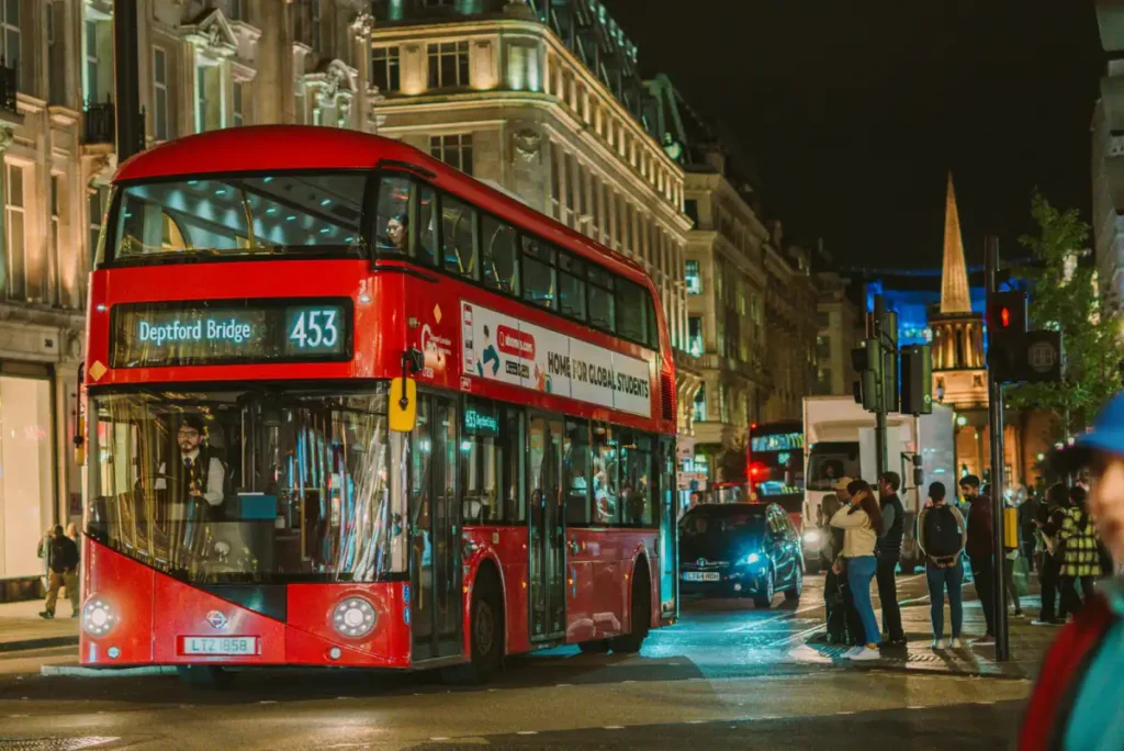 A red double-decker bus on Oxford Street under the Christmas lights in London