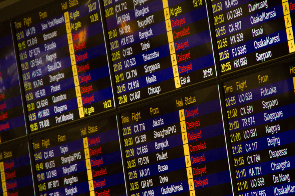 Close-up of a flight information board showing departure times and gates