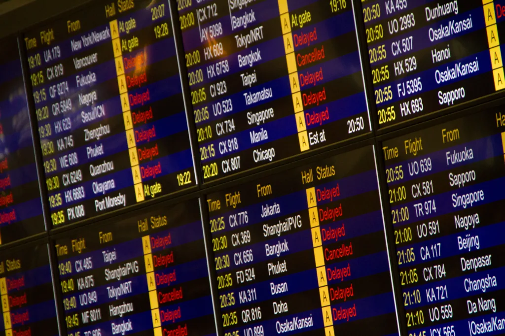Close-up of a flight information board showing departure times and gates