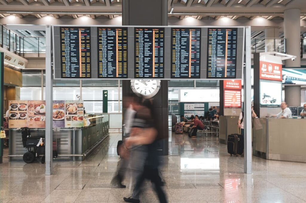 Travellers walking through an airport terminal concourse