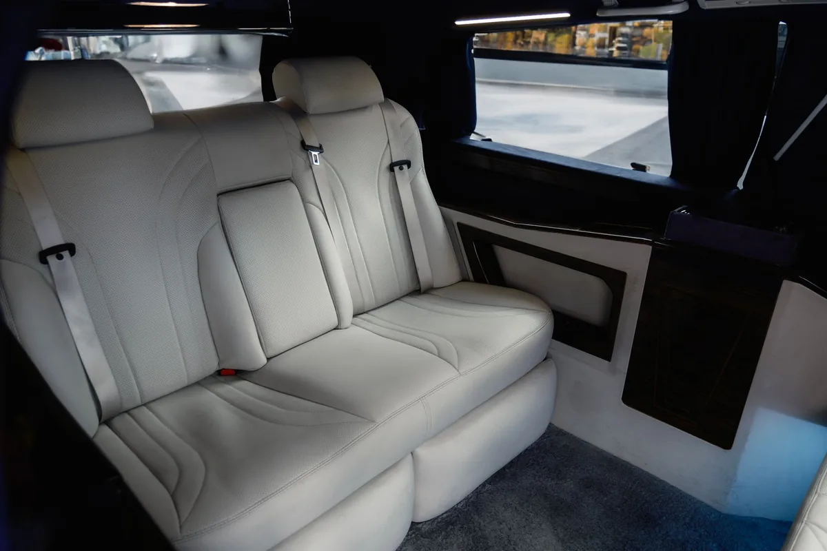 Mercedes V-Class chauffeur in London مقاعد مرسيدس V-Class الجلدية الفاتحة المتقابلة في المقصورة الخلفية