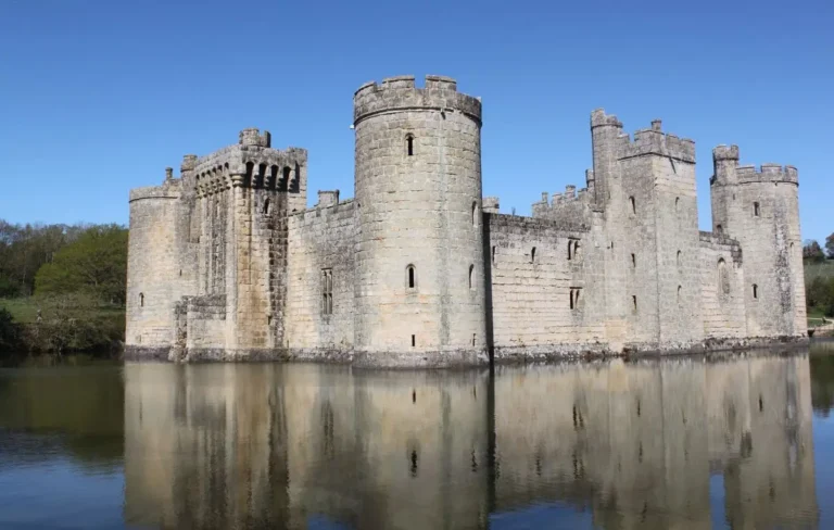 Bodiam Castle, one of the castles near London, with its round towers reflected in the moat