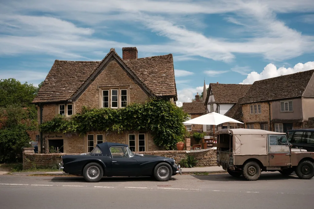 Stone cottages and classic cars on a quiet Cotswolds village street