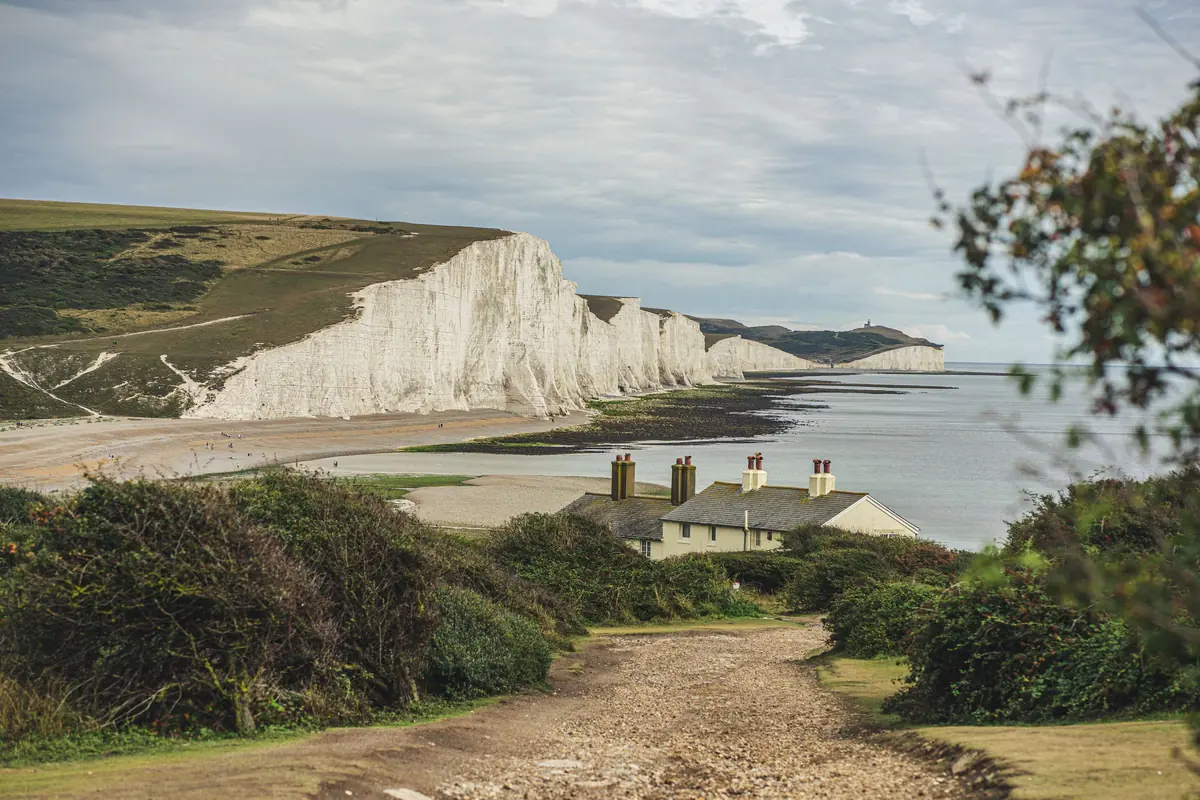 Coastguard cottages at Cuckmere Haven with the Seven Sisters cliffs behind, on a private car day trip from London