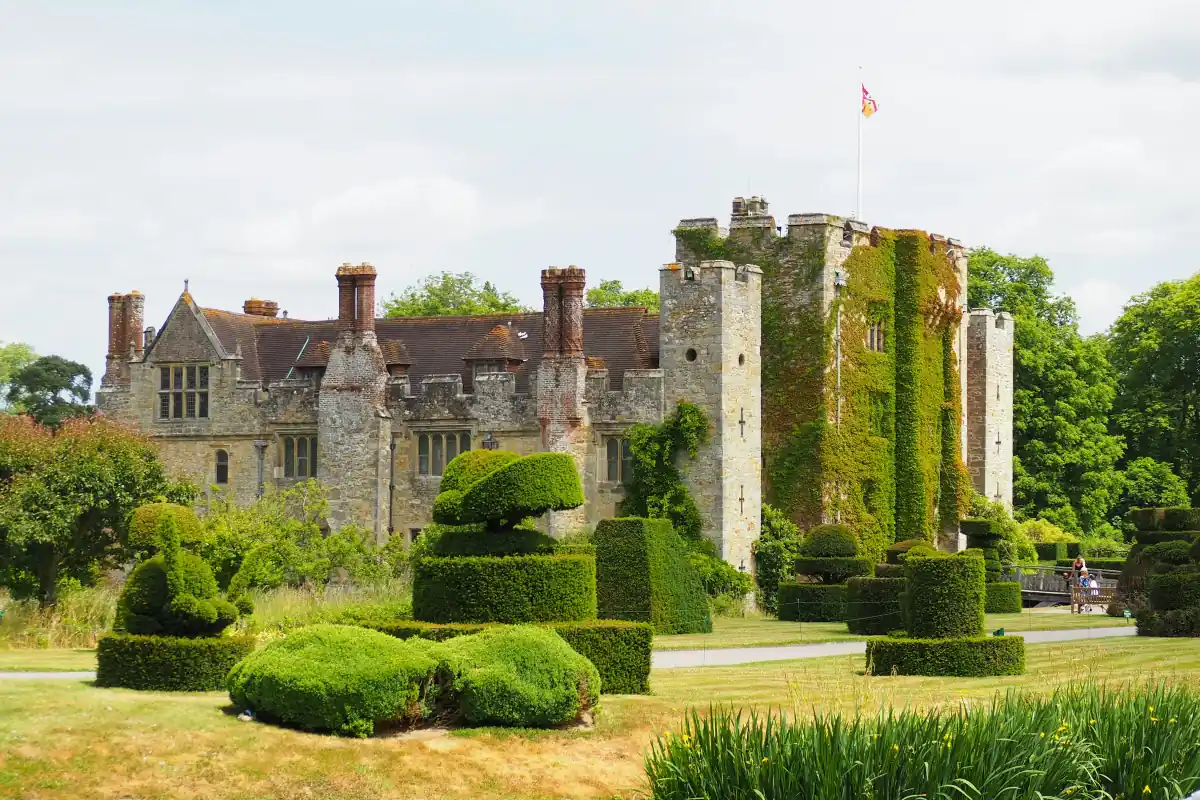 Hever Castle’s ivy-covered gatehouse behind clipped yew topiary