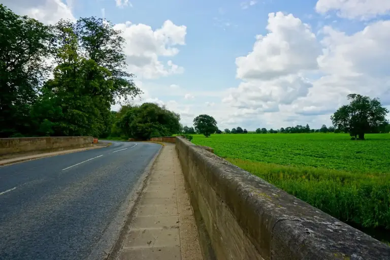 Quiet country road through green English fields, the last miles of the drive from London to Ascot Racecourse