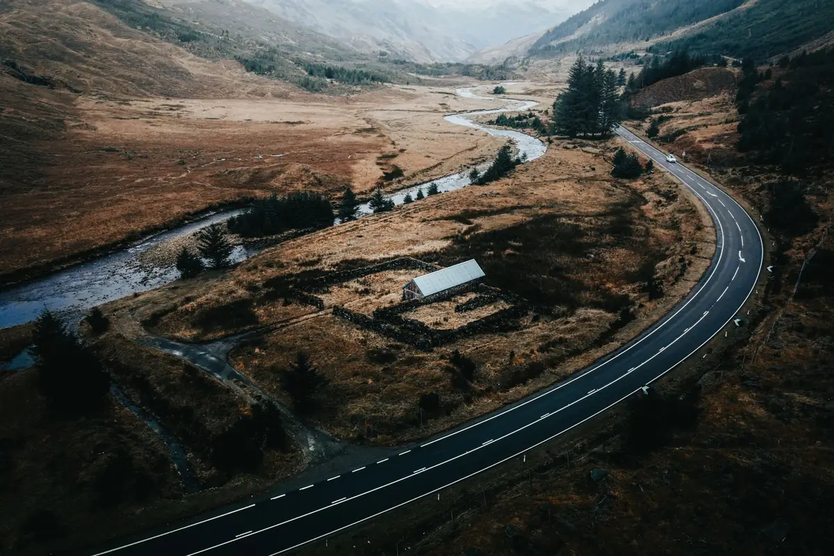 Aerial view of a winding road through the Scottish Highlands on a private driver tour