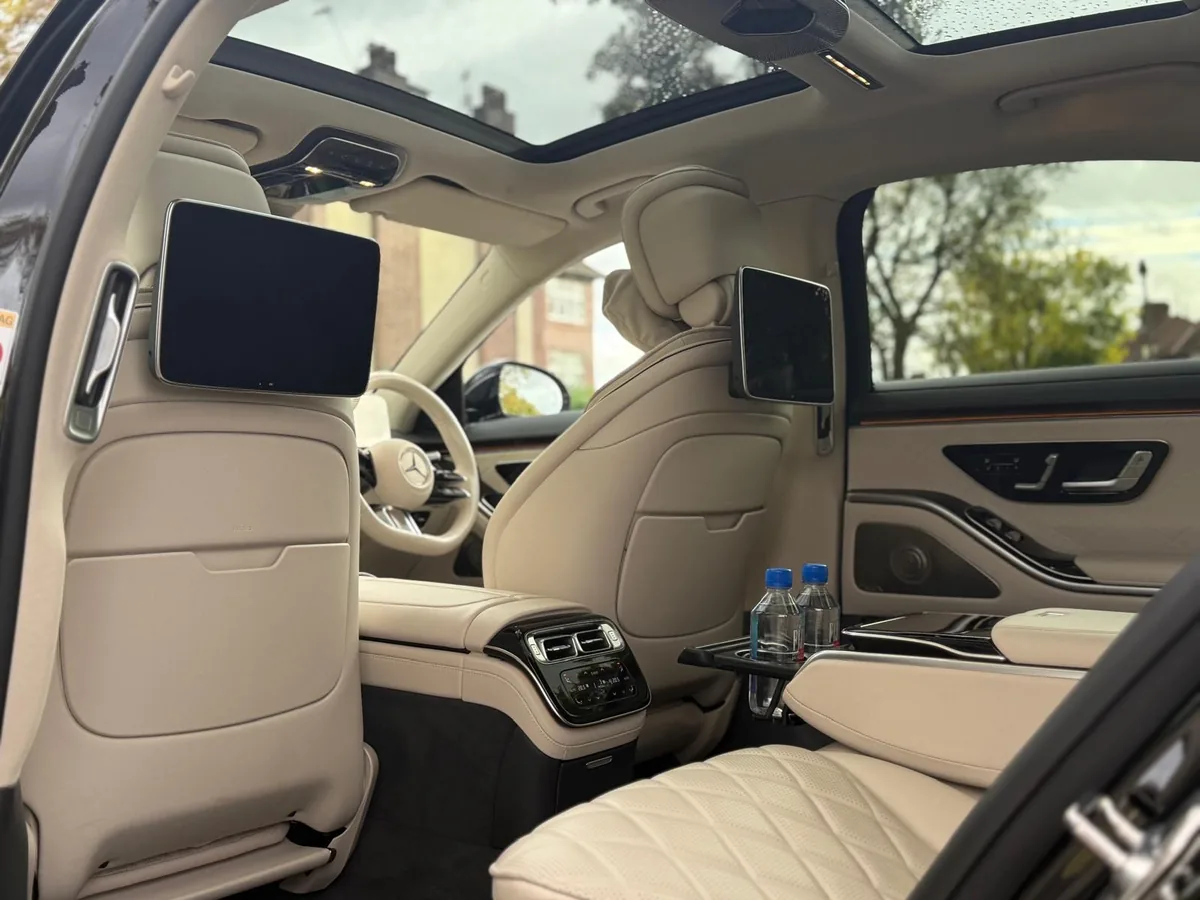 Rear cabin of the Tripyana Mercedes S-Class with cream leather seats and screens