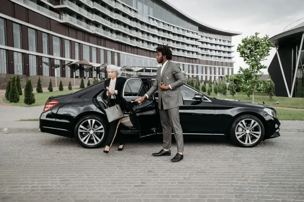 Chauffeur in a suit opening the rear door for a business passenger in London
