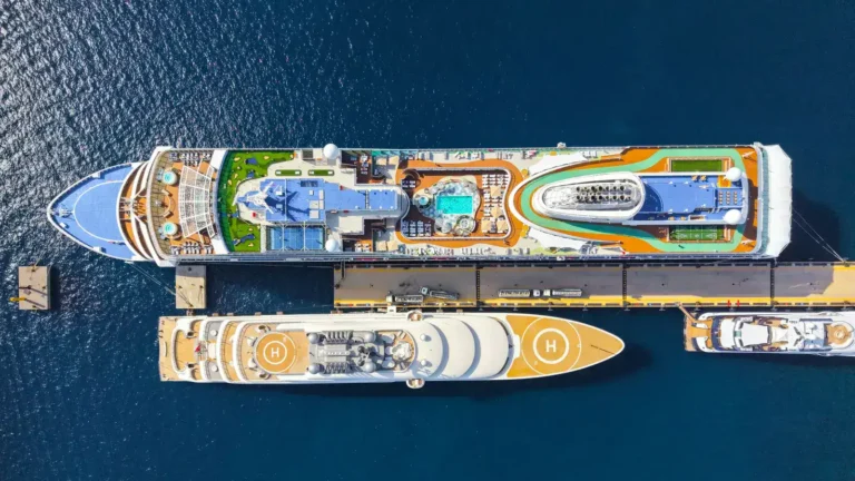 Two cruise ships moored side by side at a port, seen from above