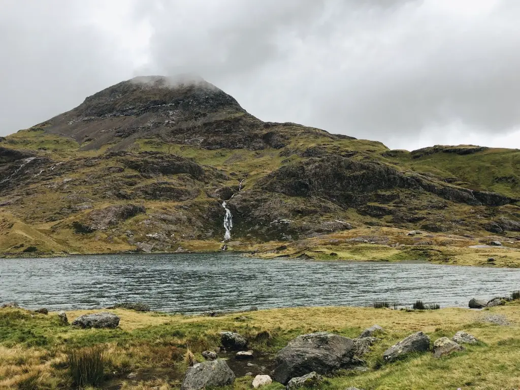 A mountain lake below the peaks of Eryri in North Wales, seen on the 2-day Snowdonia tour from London