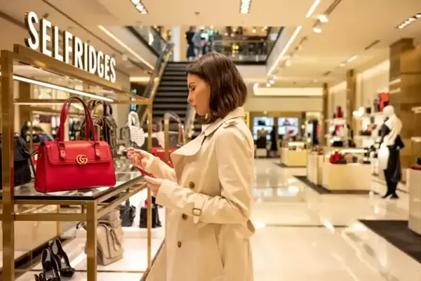 A shopper looking at handbags in a London department store